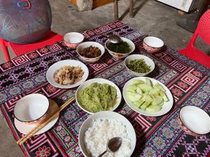 a table topped with bowls of food with rice and vegetables at Red Dao Homestay and Entire bungalow in Tả Van +57 photos