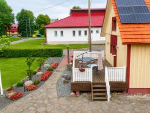 a patio with two chairs and a table and a house at Kalvi tee Puhkemaja in Viru-Nigula