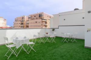 a patio with a table and chairs on the grass at La Inmaculada Alojamientos in Málaga