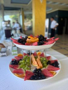 a three tiered plate of fruit on a table at Hotel Liburnia Vitamin Aga in Golem