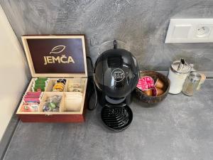a coffee maker next to a box and a basket of food at Apartmány Branná hodnocení 10 Wellness Vleky 5 min in Horní Branná