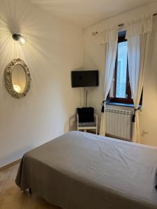 a bedroom with a bed and a mirror and a tv at Affittacamere Le Canossiane in Piedimonte dʼAlife