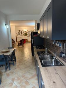a kitchen with a stainless steel sink and a table at Affittacamere Le Canossiane in Piedimonte dʼAlife