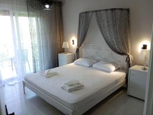 a bedroom with a bed with white sheets and pillows at Iris Villa in Apolpaina +12 photos