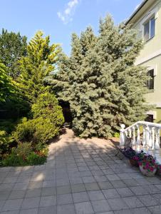 a patio with two trees and flowers in front of a building at Дом на Одесской ул. in Chornomorsk