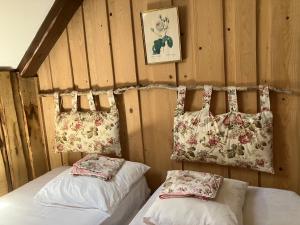 two beds in a room with wooden walls at Gîte Béthel in Lachamp-Raphaël