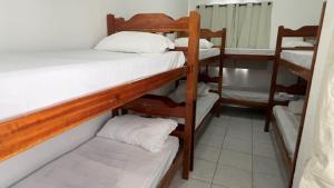 a room with three bunk beds in a room at Encantos do Mar Hostel in Recife