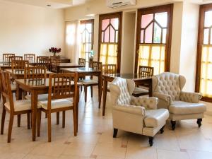 ein Esszimmer mit Tischen, Stühlen und Fenstern in der Unterkunft HOTEL ANCONA Rio Colorado RN in Río Colorado
