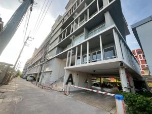 a building on a street with a parking garage at The Patio Bangsaen Cozy Condo in Chon Buri