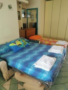 a room with two beds and a blue bedvisor at Monolocale Ischia Isola Verde in Ischia Town