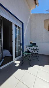 a table and a chair on a patio at Soleil Bleu in Vila Nova de Milfontes