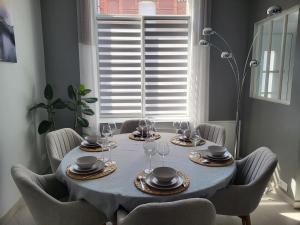 a dining room table with a blue table cloth and chairs at Loéli's House in Tourcoing