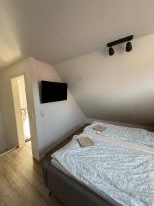 ein Schlafzimmer mit Bett und Flachbildfernseher in der Unterkunft Hüs Sanskiin in Wittdün