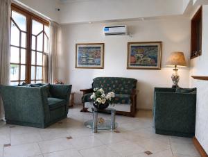 ein Wohnzimmer mit zwei Sofas und einem Tisch mit Blumen in der Unterkunft HOTEL ANCONA Rio Colorado RN in Río Colorado