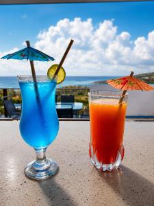 two cocktails sitting on a table with a view of the ocean at Le Marin, Rodrigues Island in Rodrigues Island