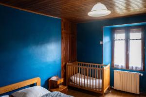 a blue bedroom with a crib and a blue wall at la margeride in Le Malzieu Forain