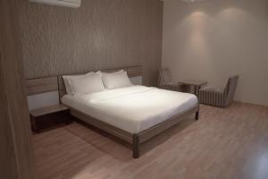 1 cama con sábanas blancas y almohadas en una habitación en Rafa Homes Al Izdihar 2 en Riad