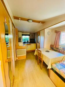 a kitchen and dining room with a table and a room at Flower Camping La Pibola in Camon