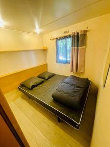 a bed in a small room with a window at Flower Camping La Pibola in Camon +33 photos