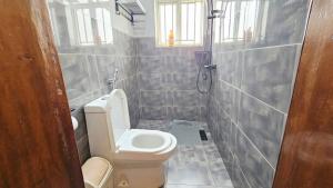 a small bathroom with a toilet and a shower at Peaceful Home in Kigali