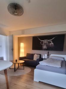 a living room with a couch and a cow on the wall at Wohlfühlen in Hohberg in Hohberg