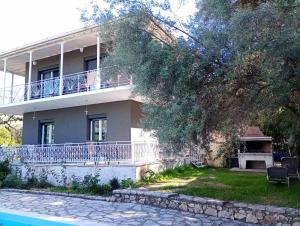 a large house with a balcony and a yard at Iris Villa in Apolpaina