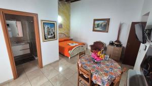 a living room with a table and a bedroom at 24 Cannoli in Leonforte