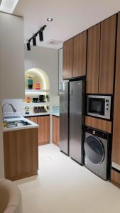 a kitchen with a stainless steel refrigerator and a microwave at Modern 2BR Apartment in Khafji in Khafji
