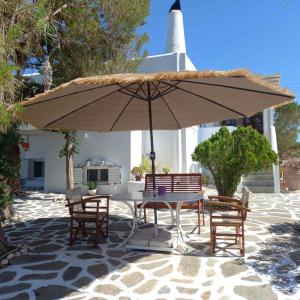 a table and chairs under an umbrella on a patio at Ampelas View in Ambelas