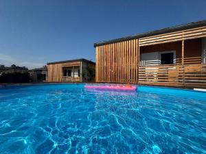 a large swimming pool in front of a building at Bungalows Sonnenblume am Klopeiner See in Sankt Kanzian