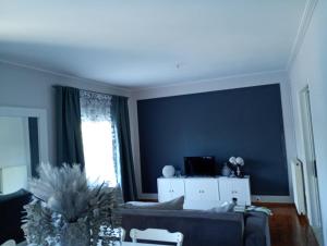 a living room with a couch and a blue wall at Iris Villa in Apolpaina