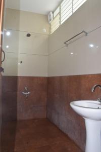 a bathroom with a sink and a shower at Sri Darshini Comfort Hinkal Mysore in Vānivilāsa Puram +29 photos
