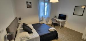 a bedroom with a bed and a desk with a computer at Pisa tower view 2 in Pisa