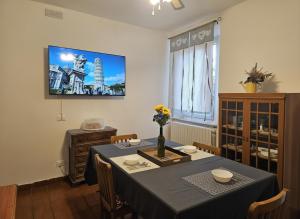 a dining room with a table and a tv on the wall at Pisa tower view 2 in Pisa