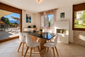 a kitchen with a dining table and white chairs at Le Cormier - Appartement 6 personnes in Ovronnaz