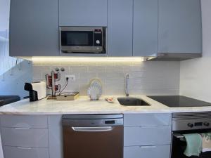 a kitchen with a sink and a microwave at Casa Da Concha in Almograve