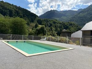 a swimming pool on a patio with mountains in the background at Maison de Max in Luz-Saint-Sauveur