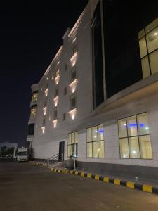 a building with lights on the side of it at night at ڤيا Via in Buraydah