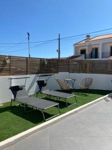 a group of chairs and picnic tables on the grass at Casa Da Concha in Almograve