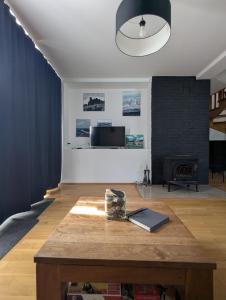 a living room with a table and a fireplace at Ostań i Odpocznij Podzamcze in Podzamcze