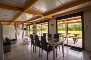 a dining room with a table and chairs at Aux étangs in Brutelles