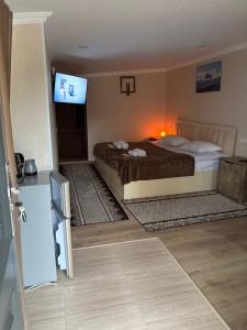 a bedroom with a bed and a flat screen tv at Kapan Guesthouse in Kapan
