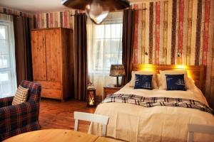 a bedroom with a bed and a couch and a chair at Ostoja Dwa Jeziora in Węgorzewo