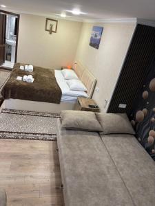 a hotel room with two beds and a couch at Kapan Guesthouse in Kapan
