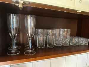 a row of empty glasses sitting on a counter at Cenkones Bungalow in Cenkoņi +1 photo