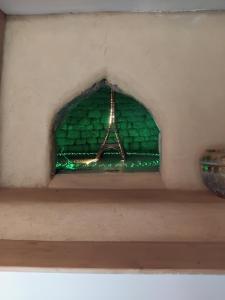 a window in a wall with a chandelier at Maisonnette meublée à la campagne in Ernée