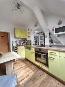 a kitchen with yellow cabinets and a wooden floor at Ferienwohnung mit Elbwiesenblick in Lutherstadt Wittenberg