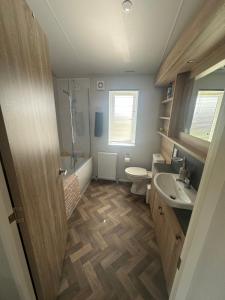 a bathroom with a sink and a toilet and a shower at Atlantic Breeze, Mullacott Park in West Down +17 photos