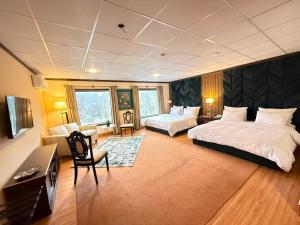 a large bedroom with two beds and a couch at The Guest House Hunza in Karimabad Hunza