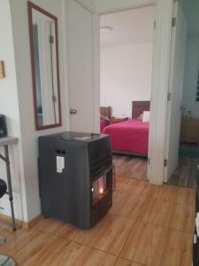 a fireplace in a living room with a bed at Cabaña Rayantu Antuco in Antuco +3 photos